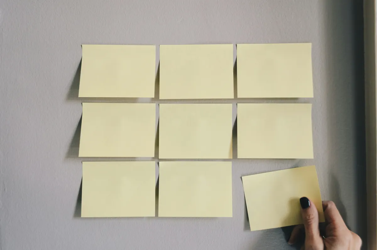 Opengeslagen notitieboek met pen op een houten bureau naast een laptop