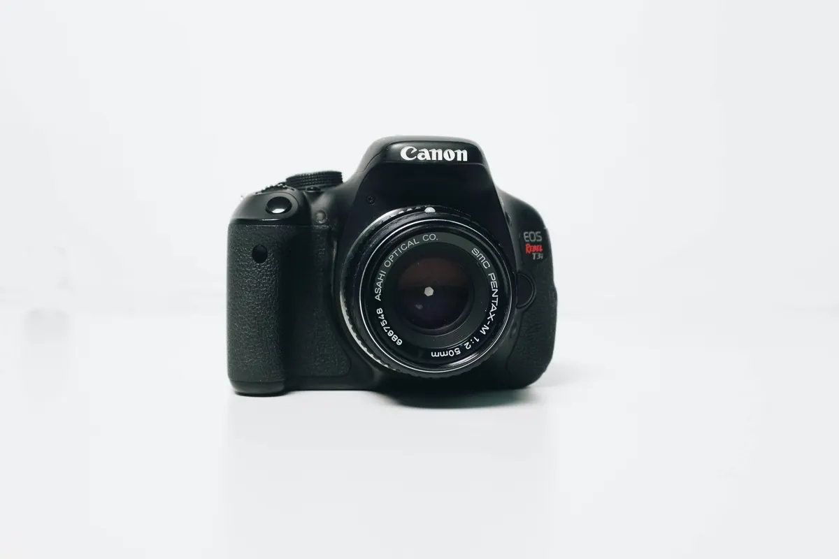 Zwarte spiegelreflexcamera tegen een witte achtergrond