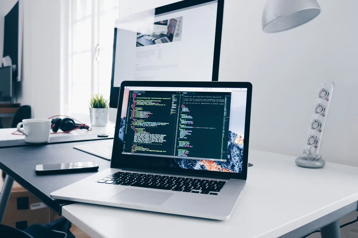 Laptop met code op een bureau in een werkomgeving