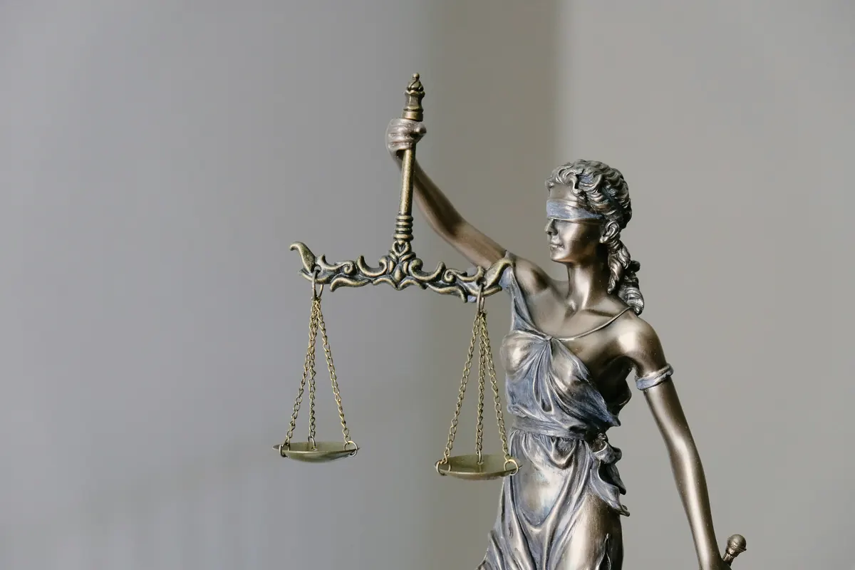 Houten rechtershamer naast juridische documenten op een bureau
